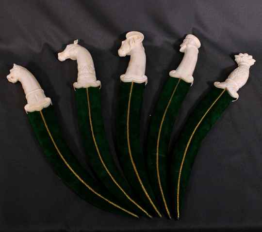 Dague avec poignée en os de chameau sculpté, lame damas simple courbure, fourreau velours vert. Forge artisanale.