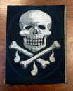 Broderie mortuaire argent réalisée par les Éts David. Têtes de mort sur fémurs et larmes. 