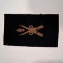 Insigne d'armurier maréchal des logis. Grande guerre. Fusils croisés et grenades entre les canons. Or/noir