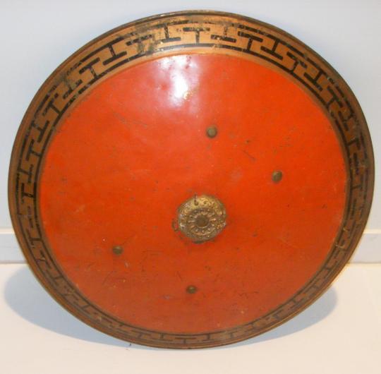 Bouclier de théâtre orange bordé d'une frise à la grecque