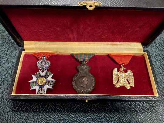 Coffret noir au profil de l'Empereur. Copies de Légion d'Honneur et débris de la Grande Armée, authentique médaille de Sainte Hélène 