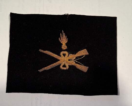 Insigne d'armurier maréchal des logis. Grande guerre. Fusils croisés et grenades séparées des canons. Or/noir 
